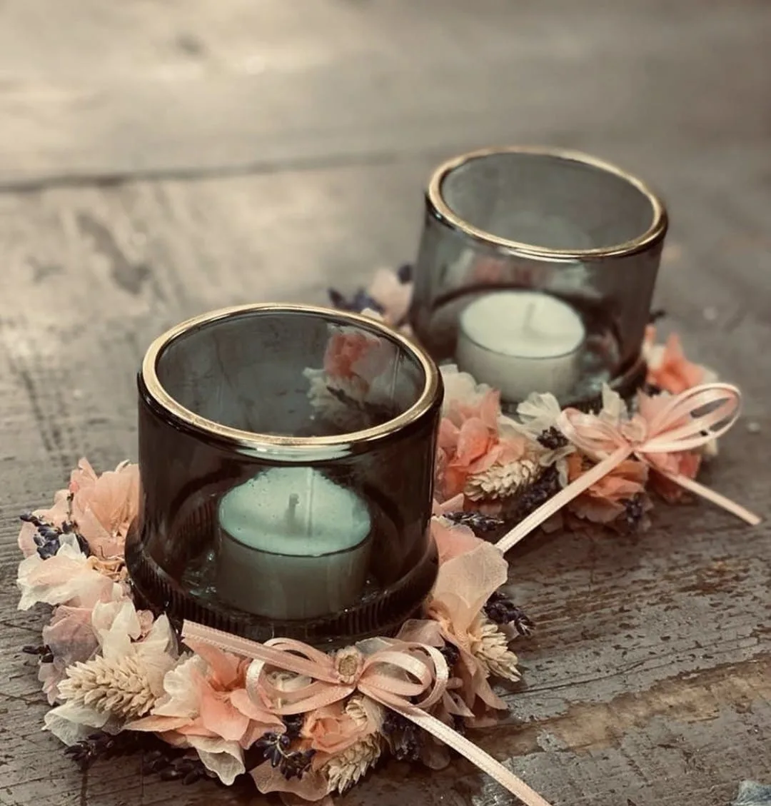 Zwei Windlichter aus Glas mit rosa Trockenblumen und Schleife