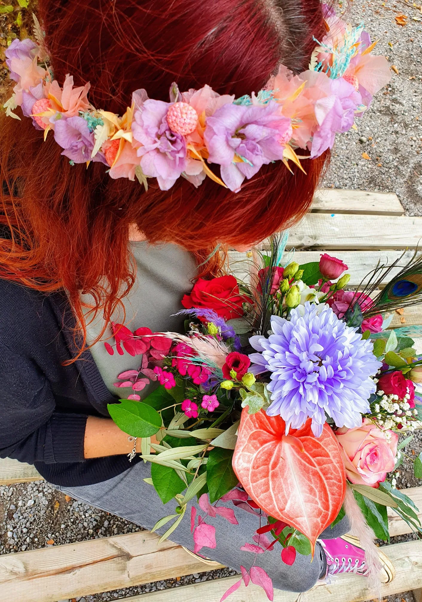Frau mit einem Kopfkranz in Pastellfarben und einem bunten Strauß im Arm