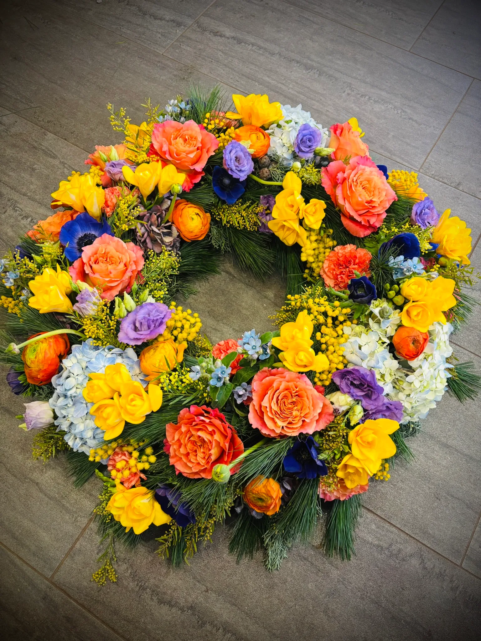 Trauerkranz in kräftigem Gelb, Orange und Blau